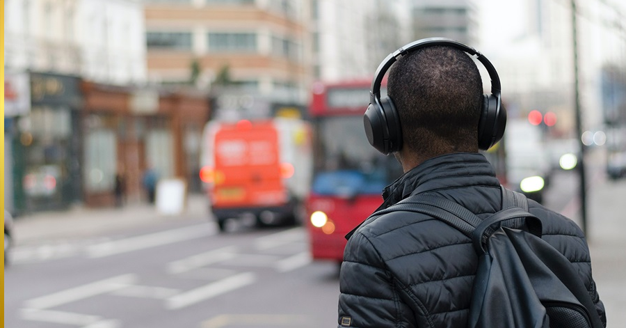 Man wearing headphones while waiting for bus